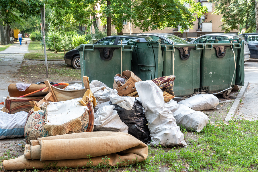 An overflowing dumpster near an office building showing the need for commercial junk removal Los Angeles.